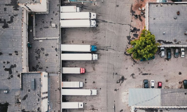 Bird's eye view of trailers backed up and parked in front of a building