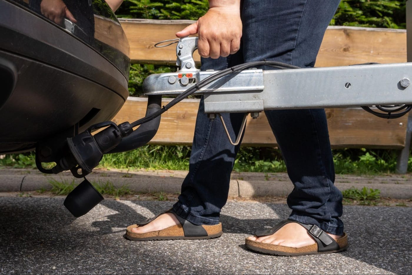 a person hooking a trailer to a ball hitch